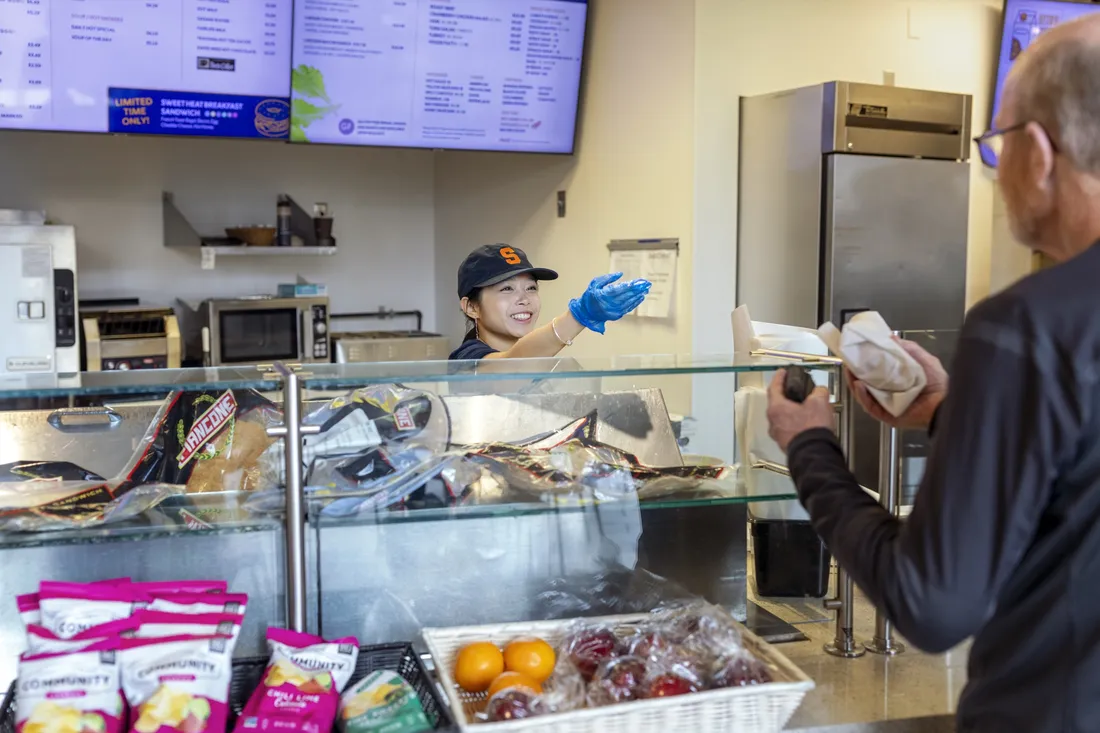 Abby Zhang '29 handing a customer their order at the Life Sciences Café.