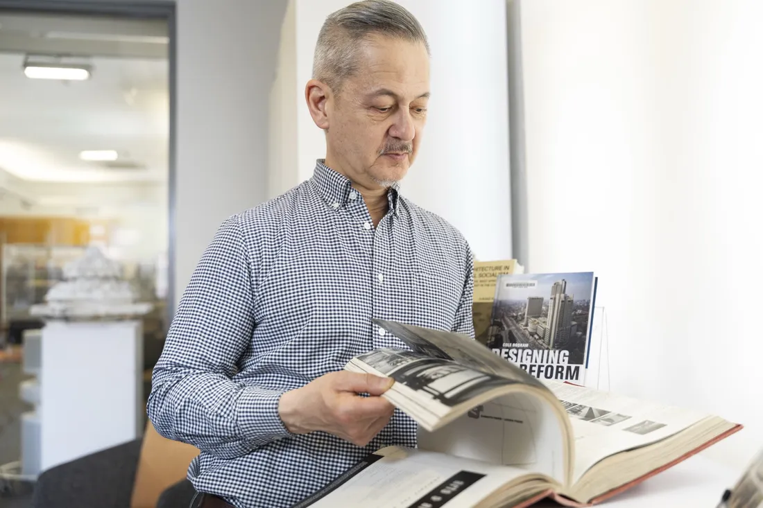 Professor Lawrence Chua flipping through an book on architecture and design.