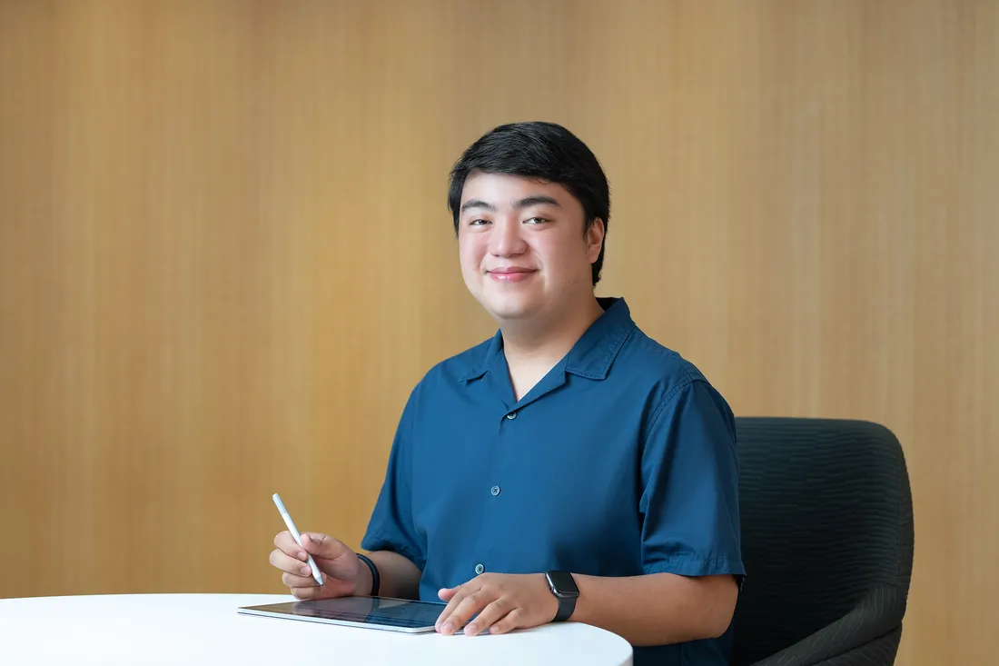 Enrique Prejula sits at desk writing on tablet