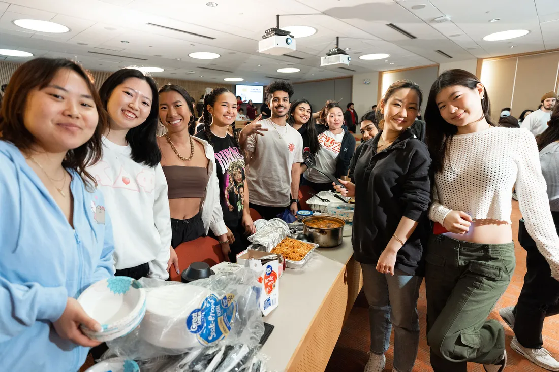 Students gather round buffet table at AAPI Night Market.