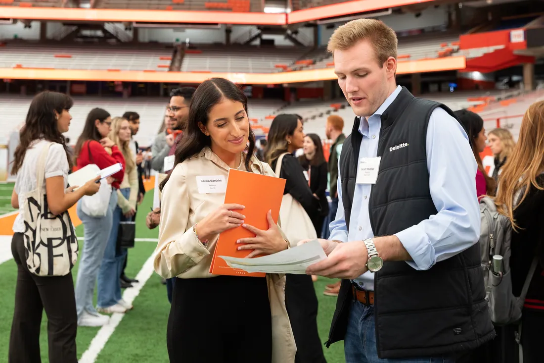 Student talking to Deloitte representative at career fair.