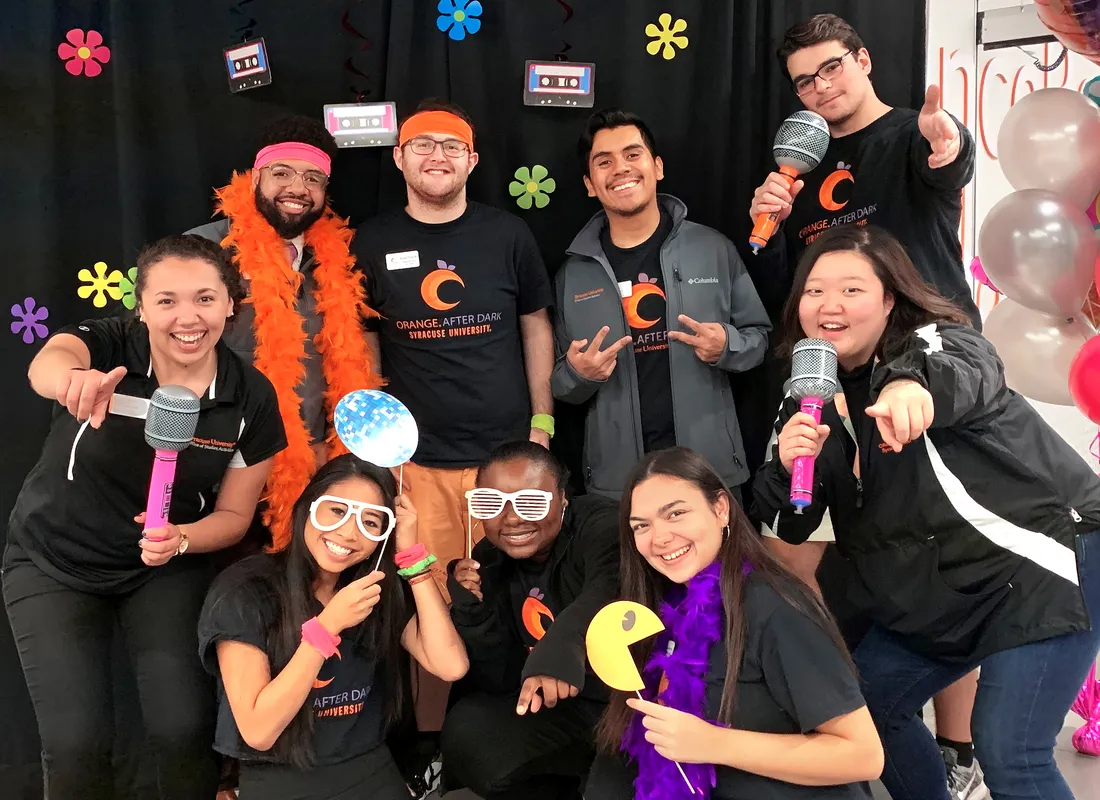 group of students in funny masks and feather boas pose for a picture