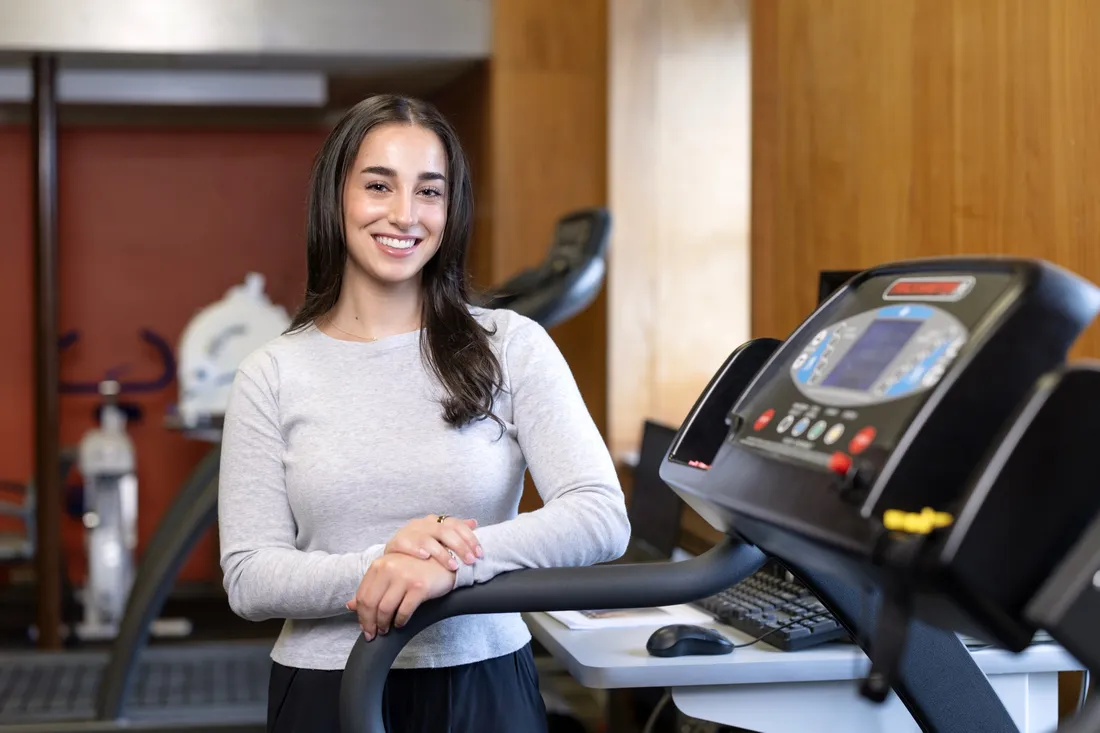 Zoe Rubin '26 standing on a treadmill and smiling.