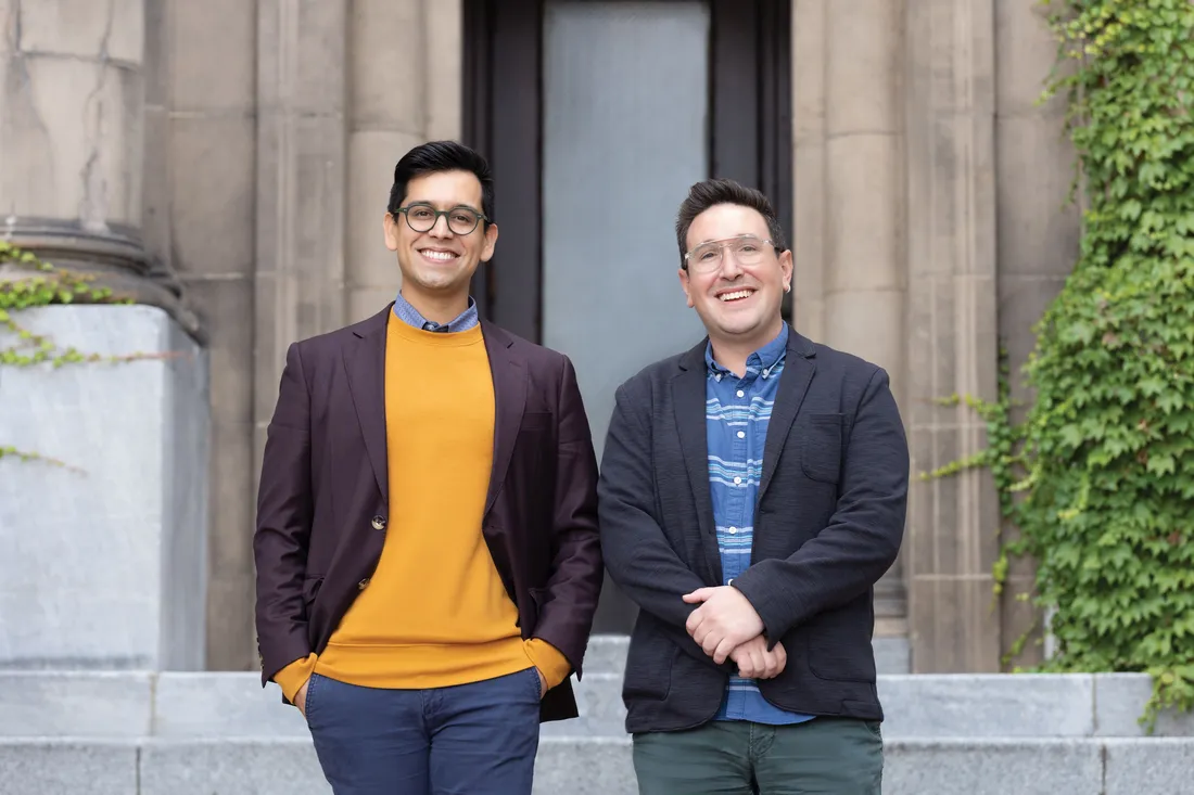 Portrait of How to Dance in Ohio co-producers Sammy Lopez and Ben Holtzman outside, both smiling.