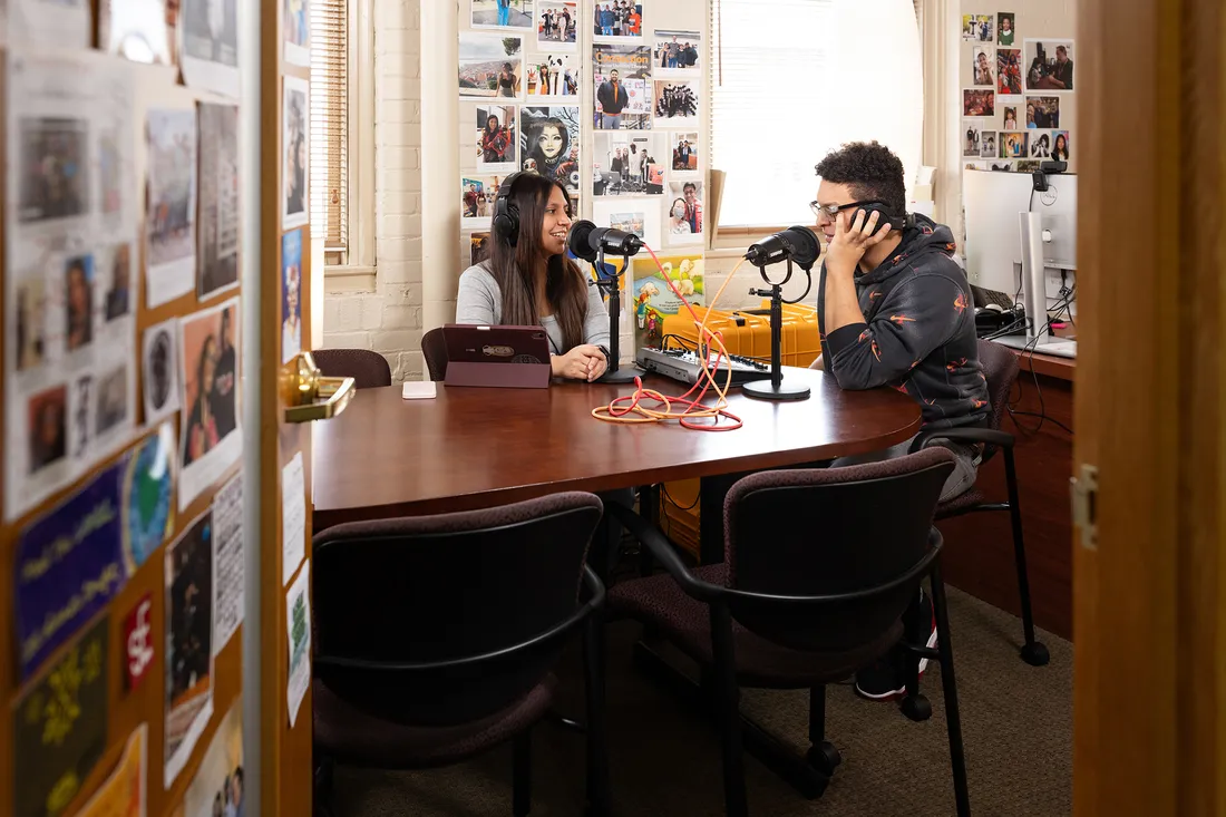 People sitting at a table and recording a podcast.