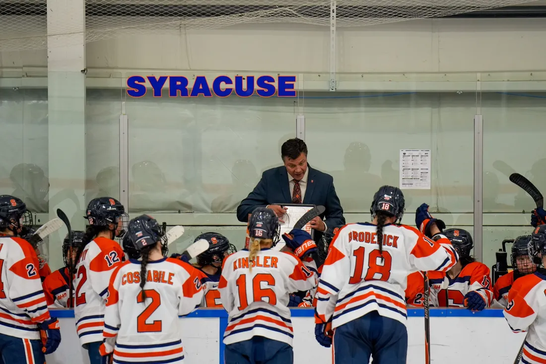 Women's ice hockey coach Brian Idalski speaking with members of the team.