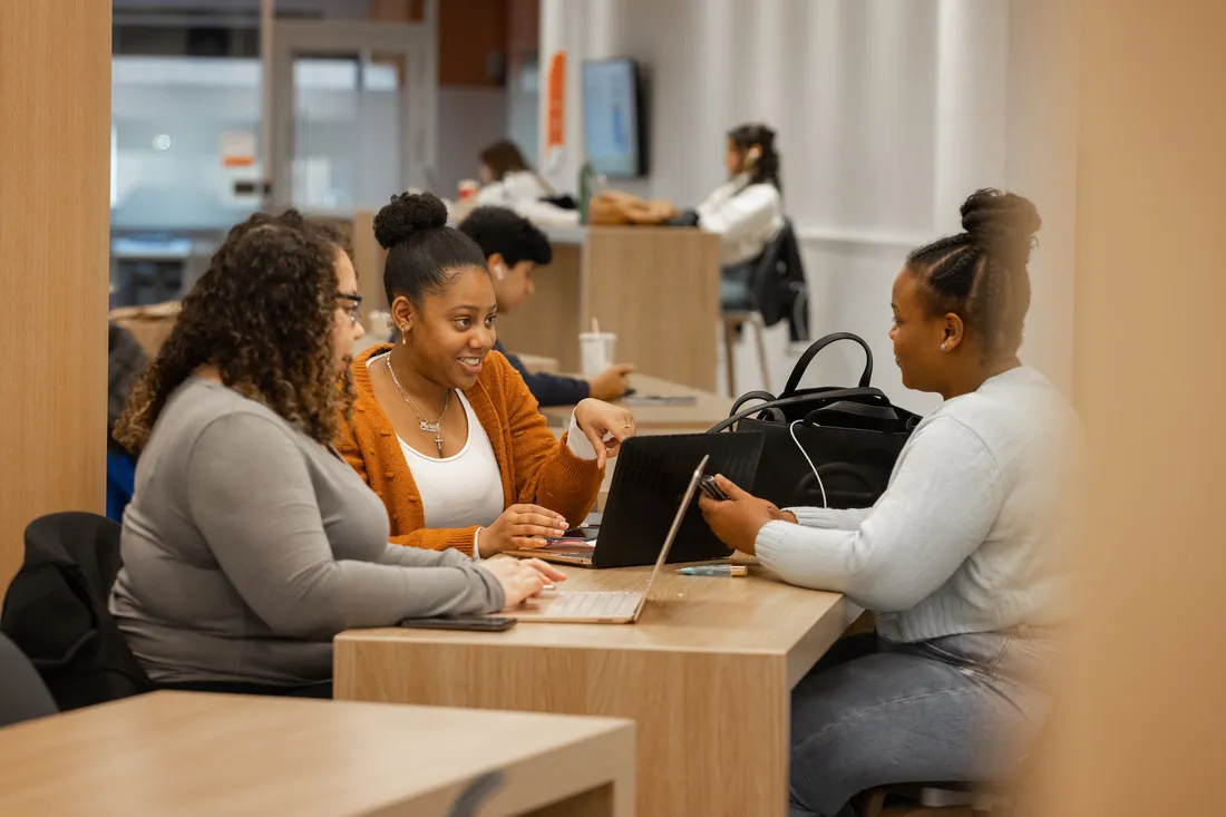 Three people sitting at a table.