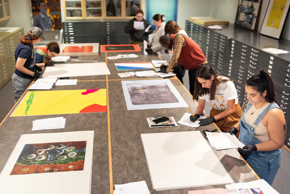 Group of students looking at prints in an art studio.