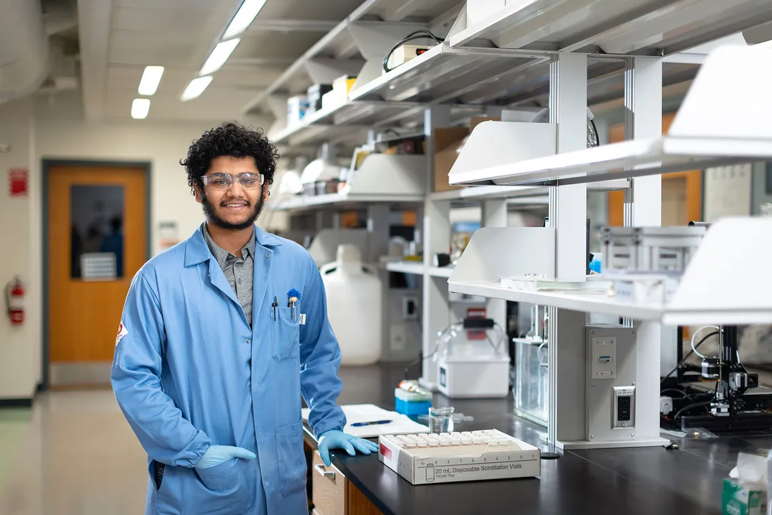Student smiling in a chem lab.