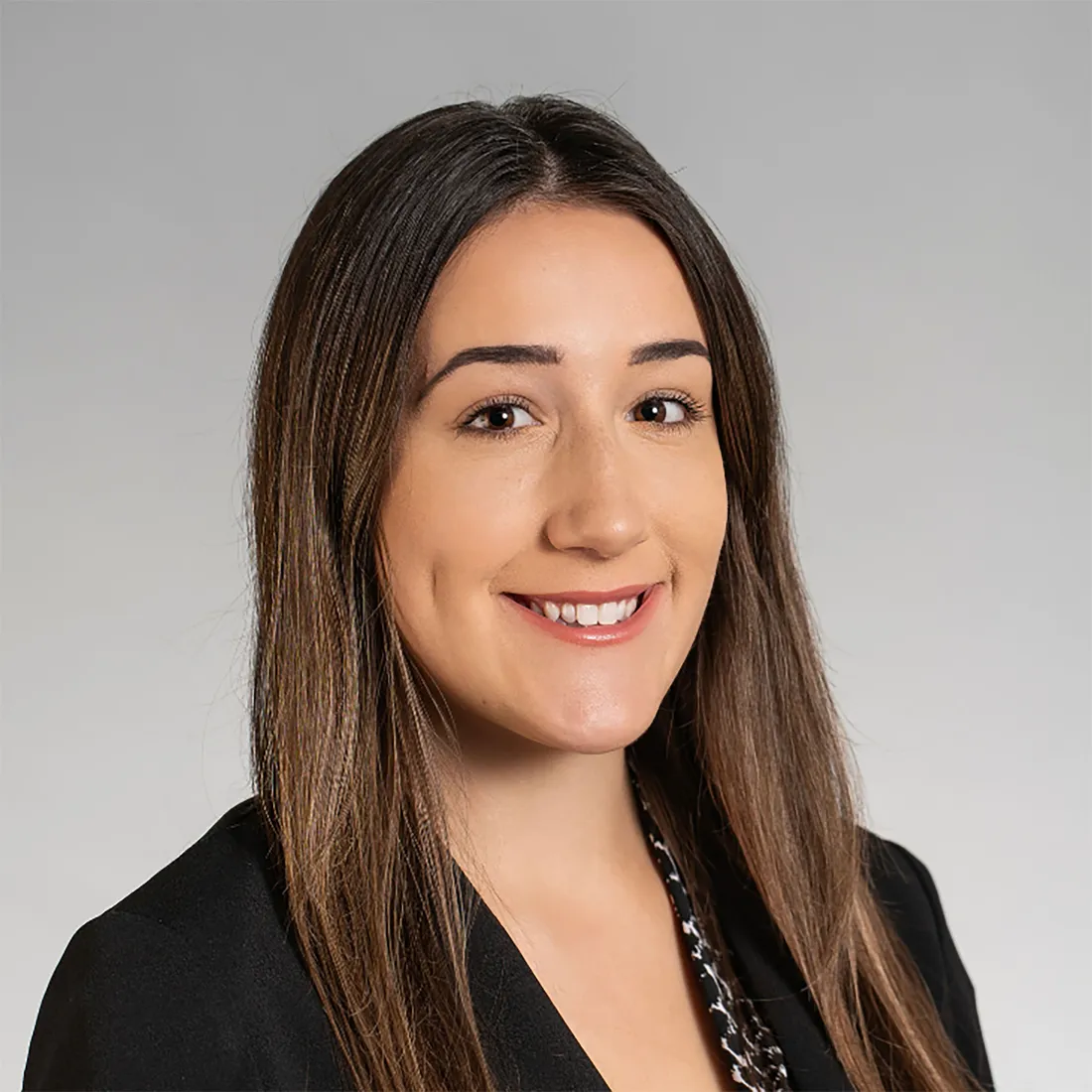 Sasha Pulaski smiling in a black blazer.