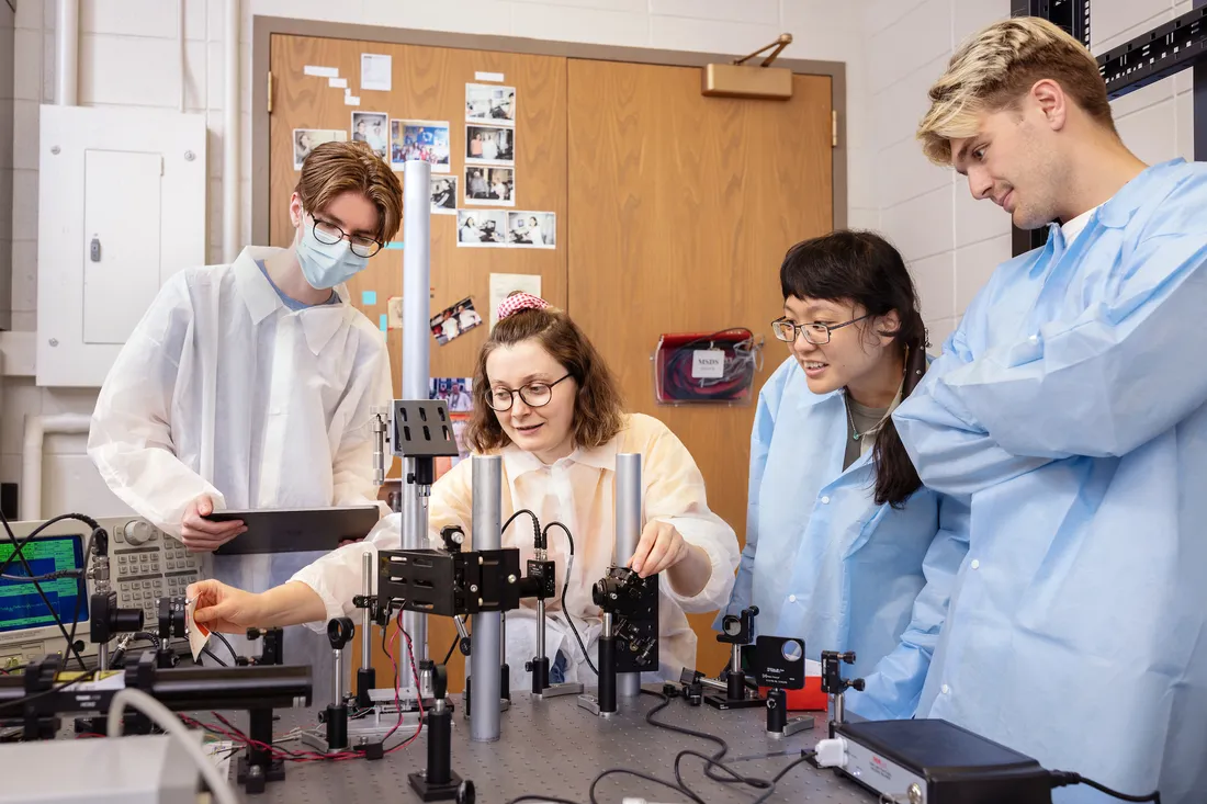 Researchers standing around a lab table working on a project.