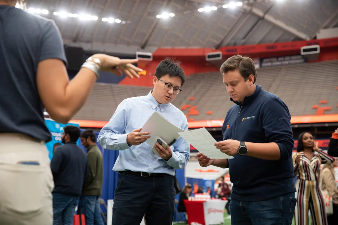 Tyler Newman standing with a student, reviewing his resume.