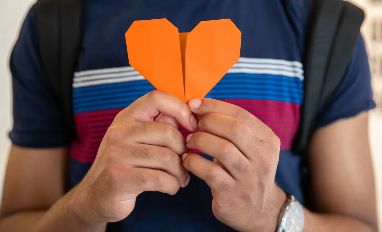 Student holding an orange origami heart.