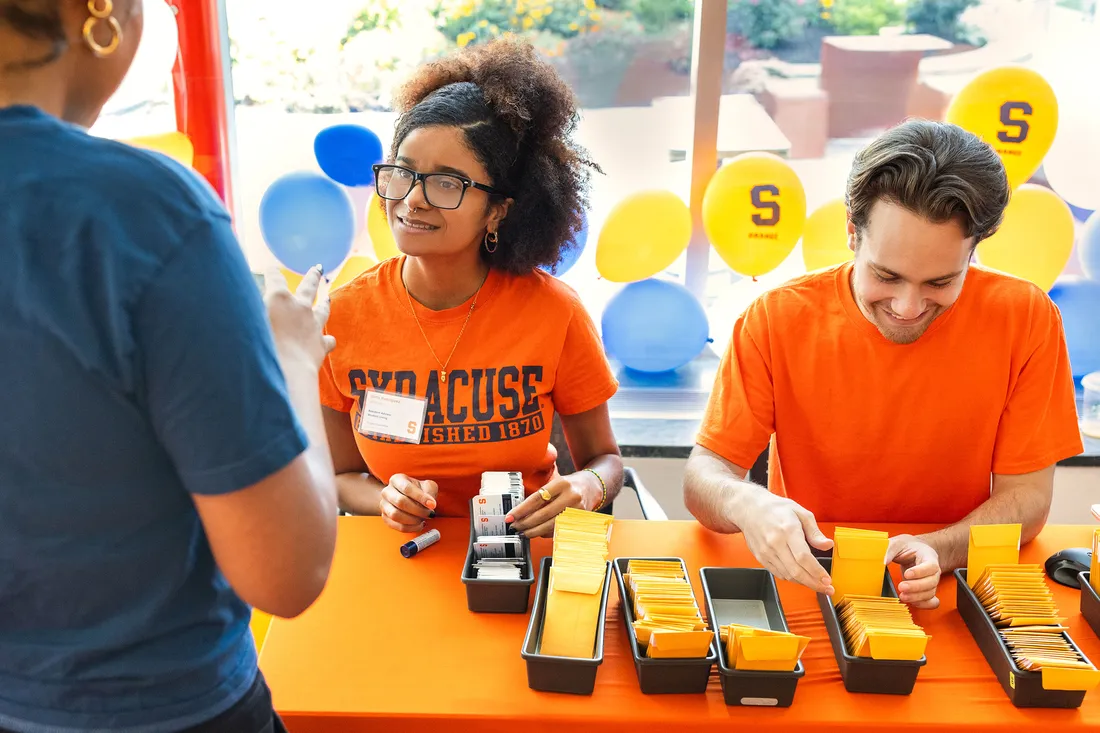 Students sitting at sign up table.