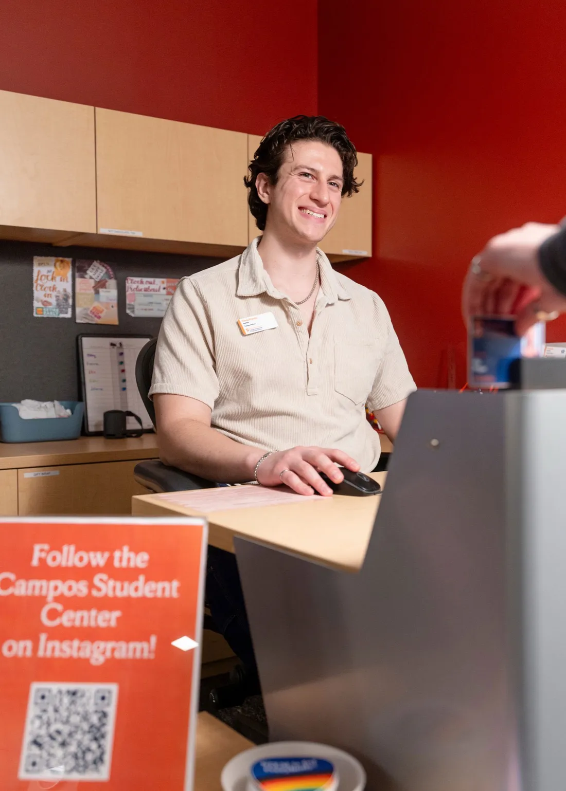 Student working at the desk of the Campos Student Center at Syracuse University.