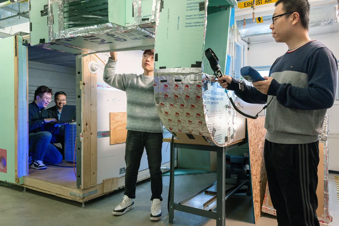 Three people working on equipment in a laboratory.