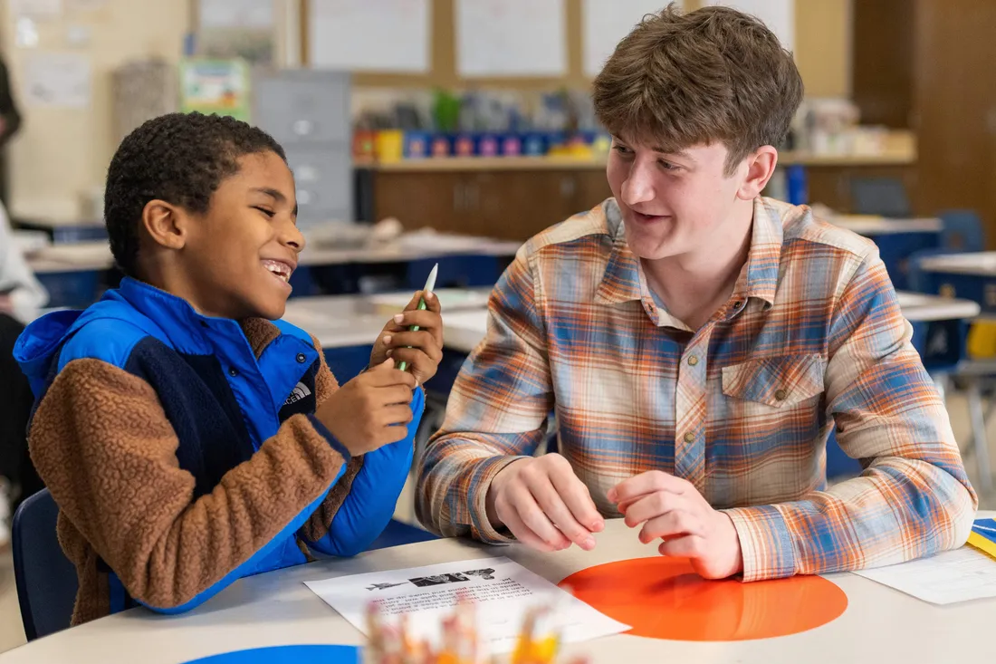 Student teacher teaching children in a classroom.