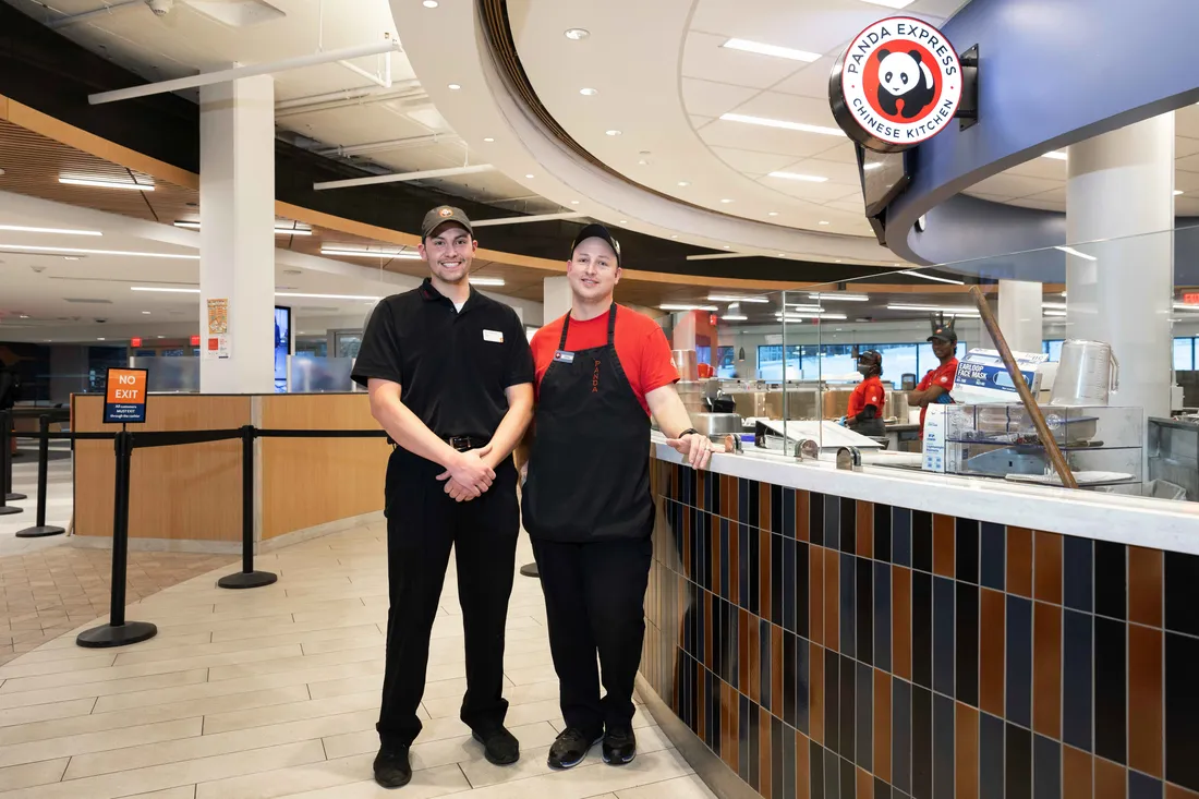 Food service staff standing and smiling.