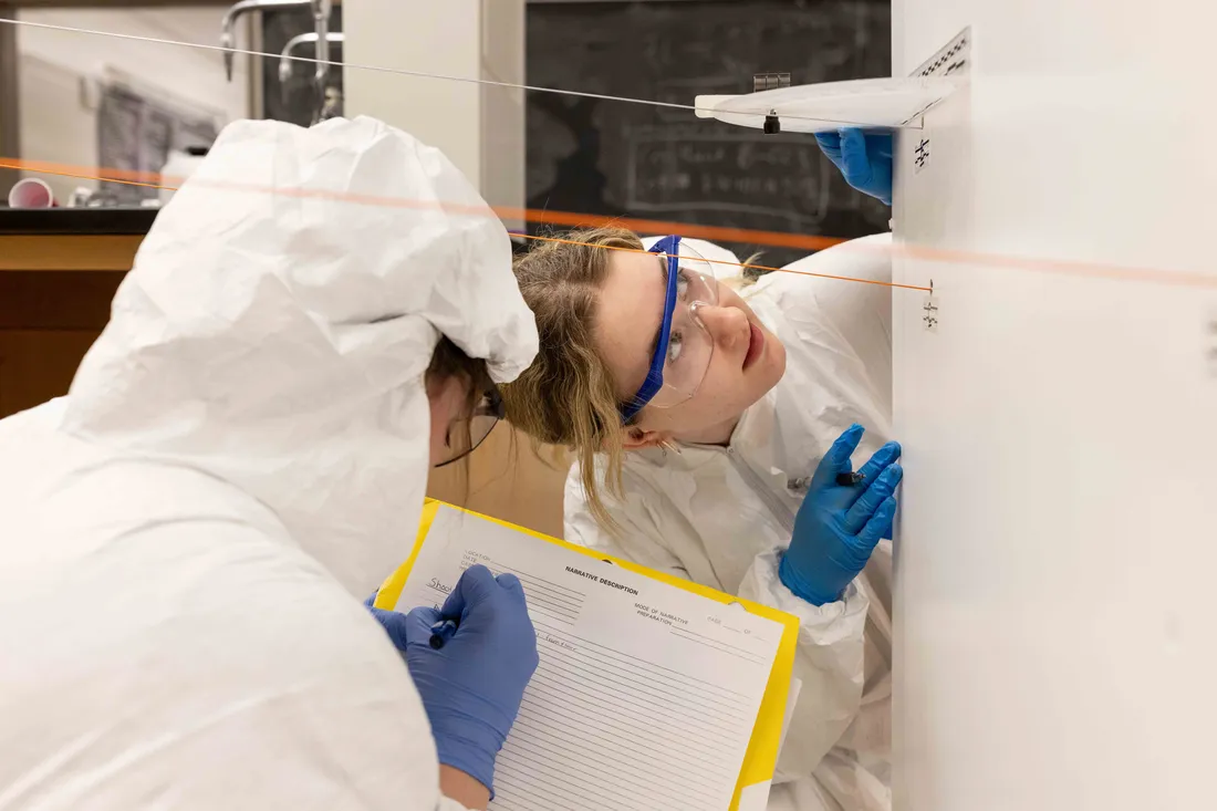 Two students working on a mock crime scene investigation.