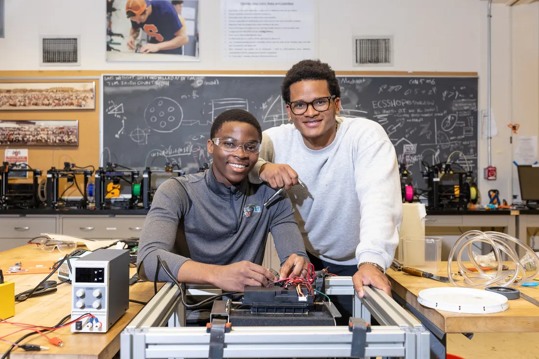 Two students sitting in a workplace.