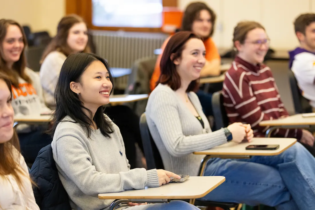 Students sitting at desk in classroom.