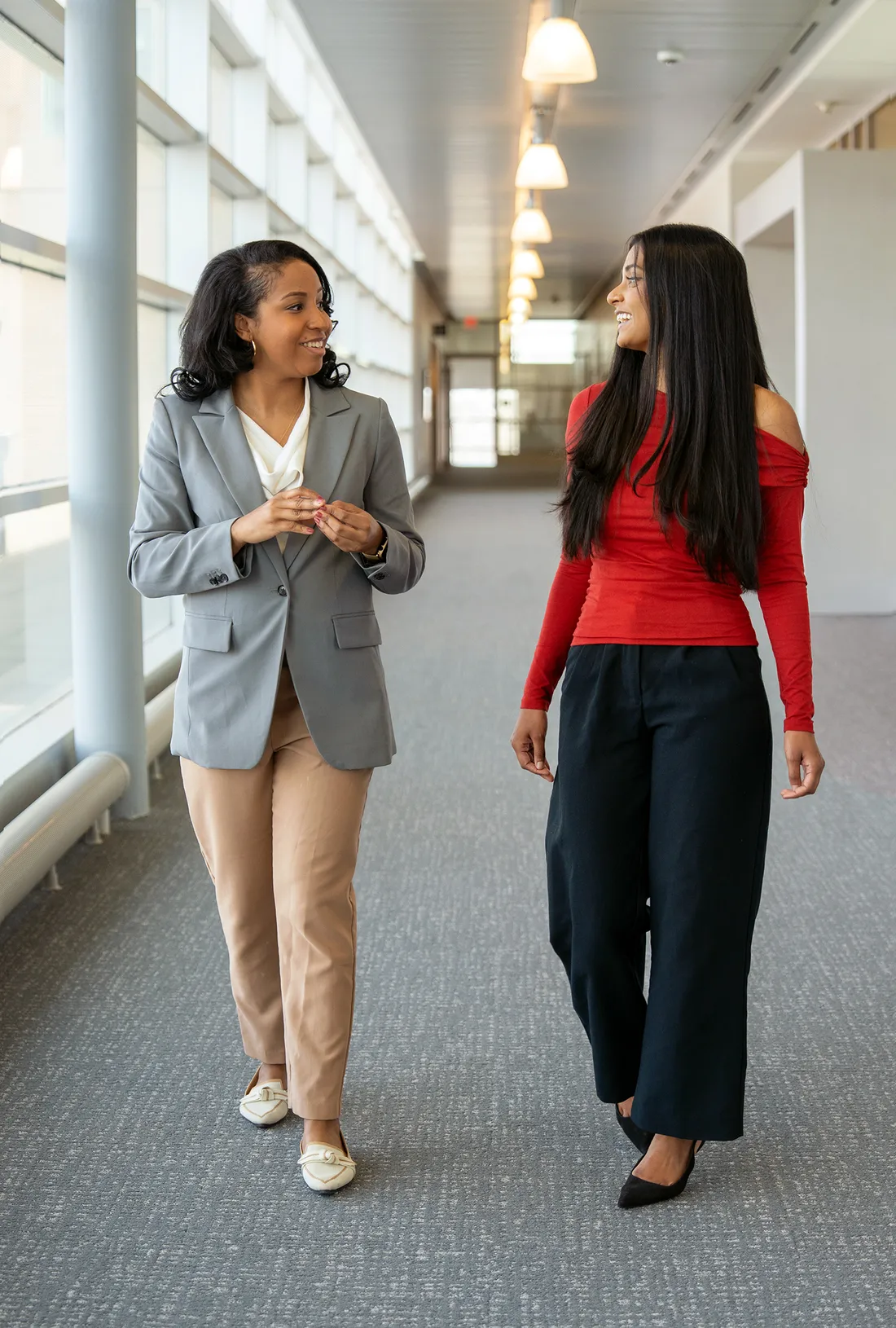 Chelsea Ransom Cooper walking down a hallway with a student.