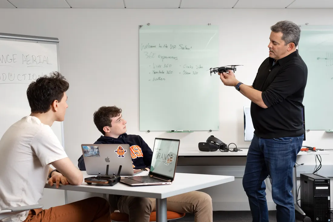 Professor giving two students demonstration.