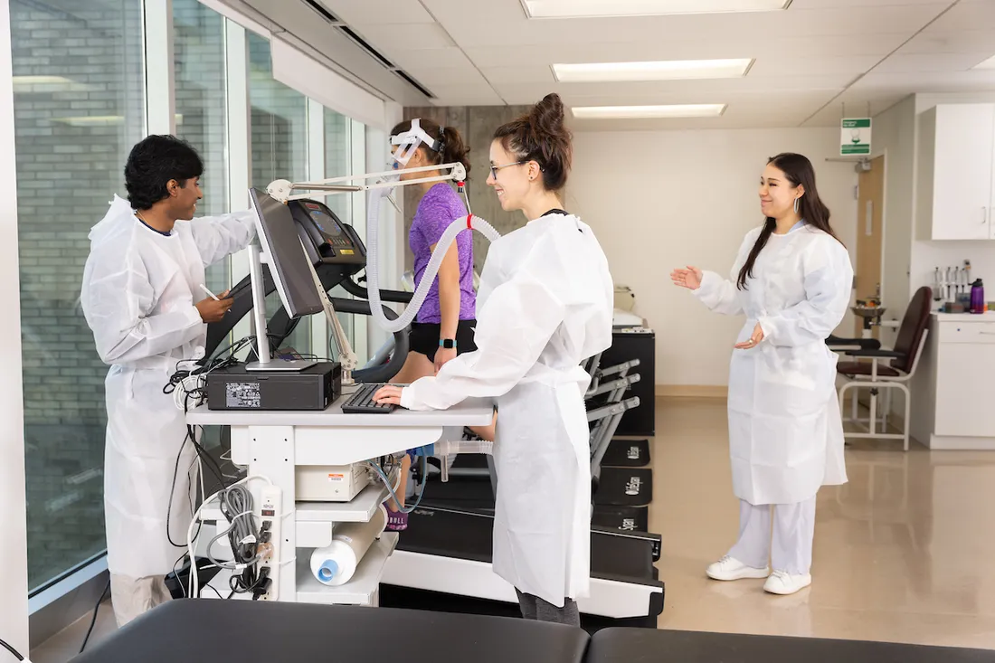 Falk College students observing a person walking on a treadmill.