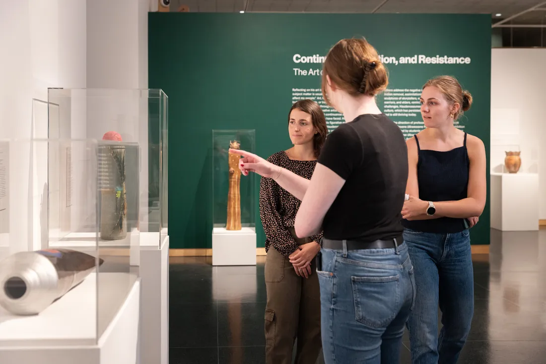 Students looking at art on display at art museum.