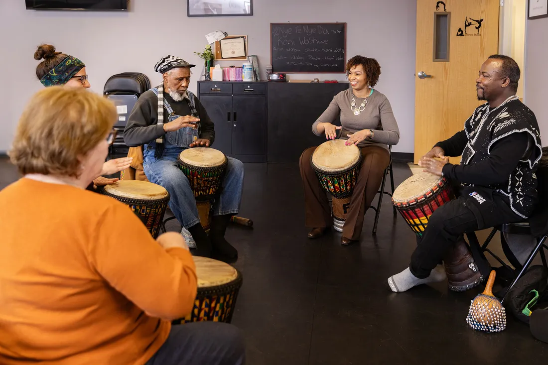 Tanisha Jackson, Assistant Professor of African American Studies and the Community Folk Art Center Executive Director, plays drums with others.