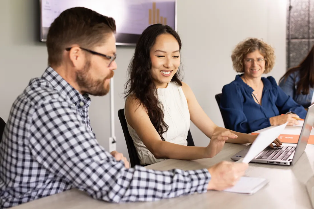 Three people at a table looking at a piece of paper.