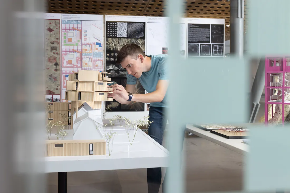 Architecture student taking a picture of project.