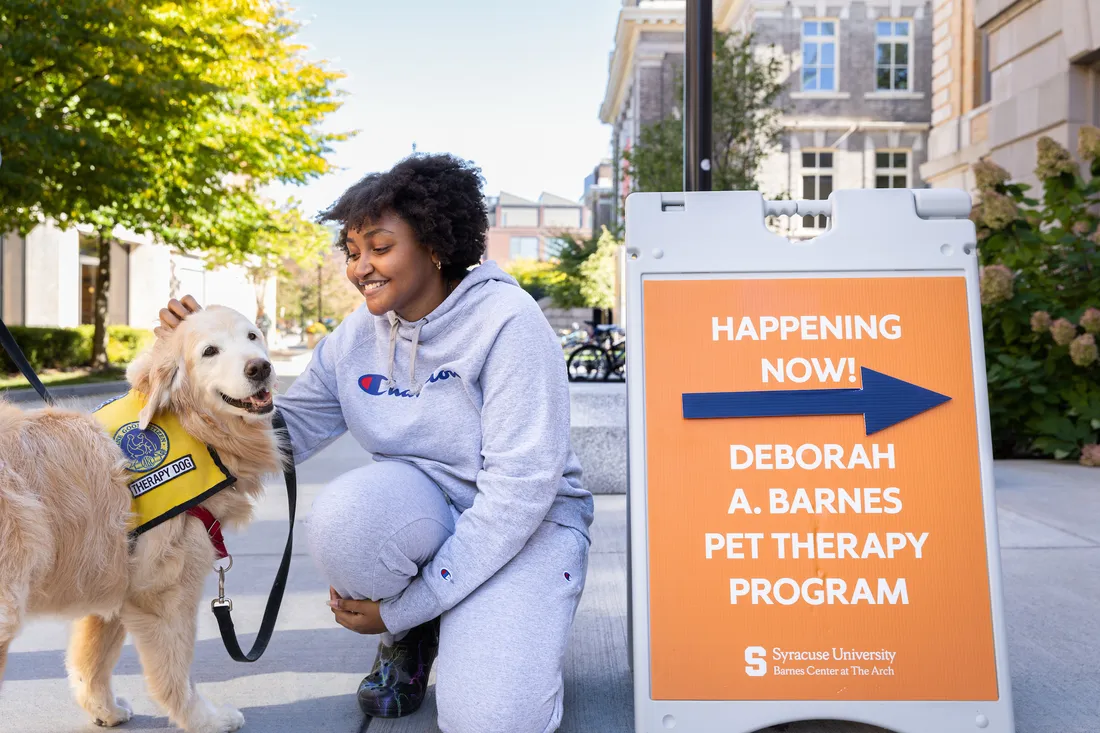 People in a pet therapy room with a pet therapy dog.